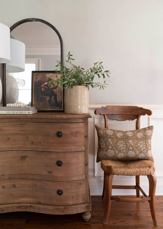 Vintage Interior Design image of French style curved chest of drawer and wooden chair with woven seat