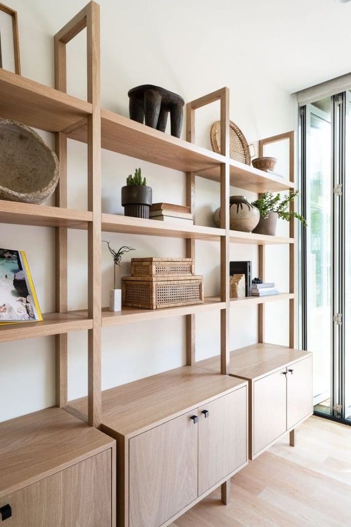 Vintage Interior Design image of Mid-Century Modern style shelving unit, styled shelves with plant pots, rattan boxes, books and framed artwork. Cupboard space to the bottom 