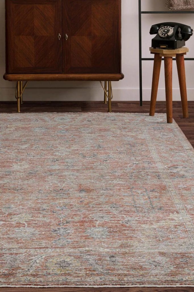 Terracotta distressed patterned rug with dark wood cabinet and old fashioned phone styling