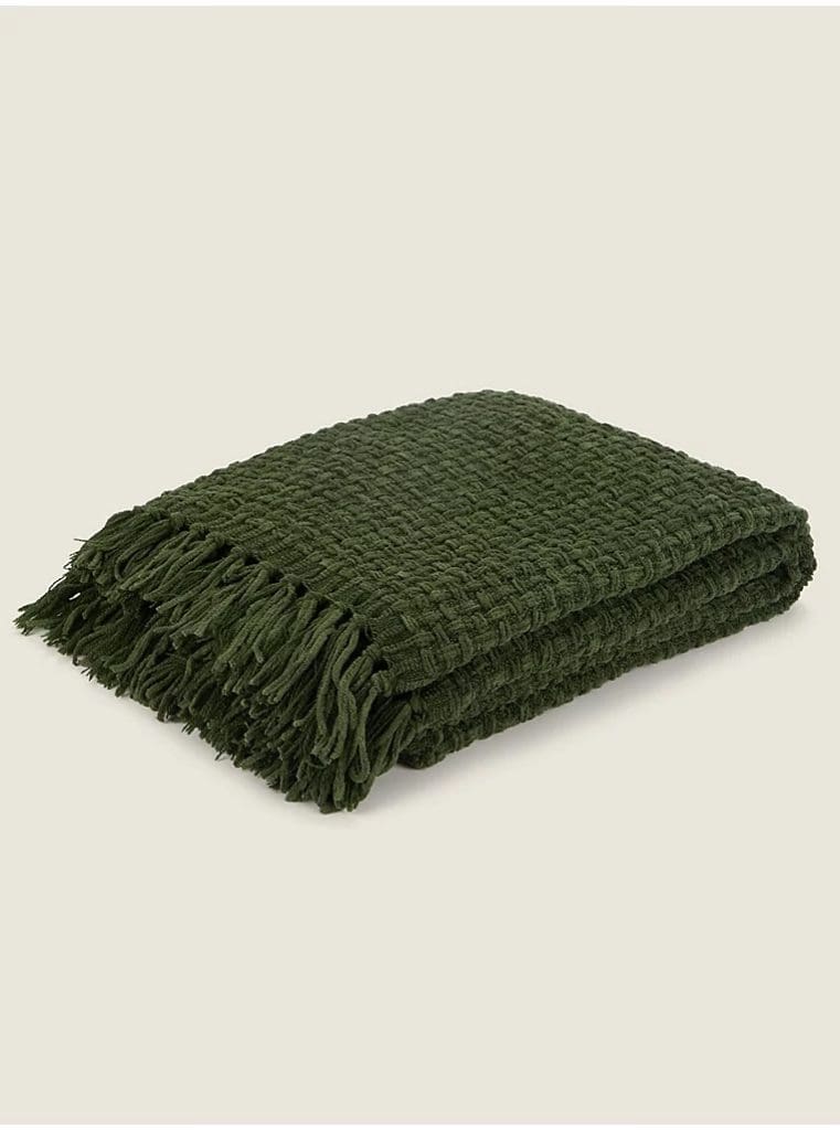 Dark forest green chucnky woven knitted throw with tasselled ends, folded neatly