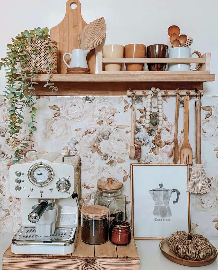 Boho-inspired coffee nook with beige floral wallpaper splashback, cream vintage-style coffee machine and light wood accessories.