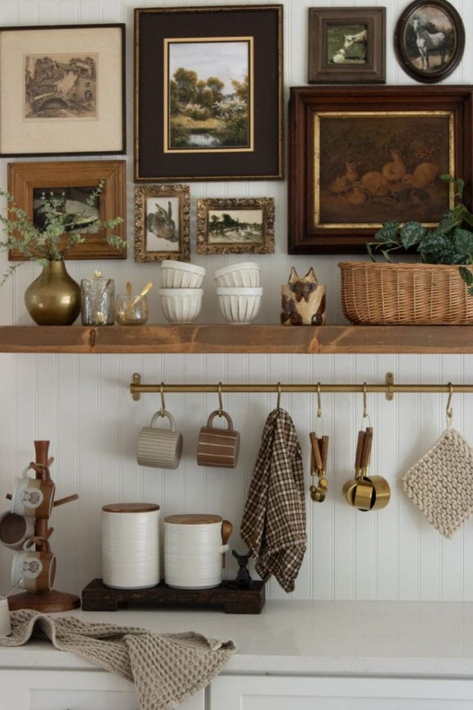 Gallery wall feautre heritage inspired artwork above a floating wooden shelve house coffee accessories such as cups, woven baskets and spoons