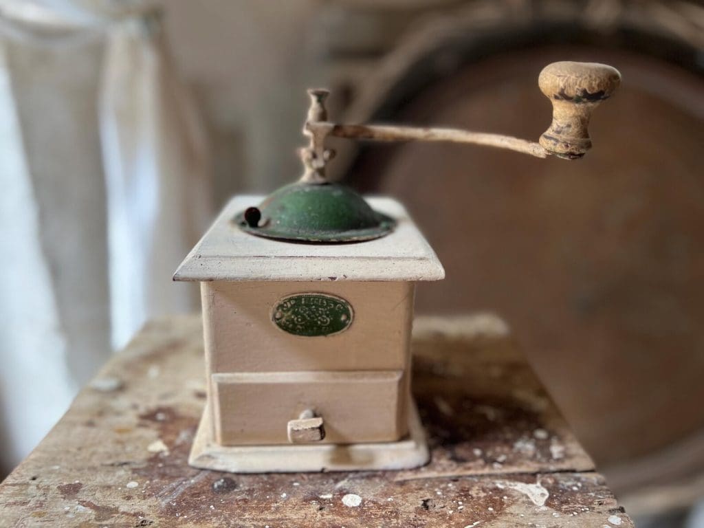 Vintage coffee box grinder with brass handle to the top