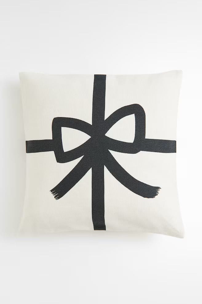 White throw cushion with printed black bow detail