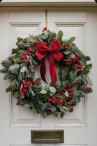 Green door wreath with red berries, leaves and big red velvet bow