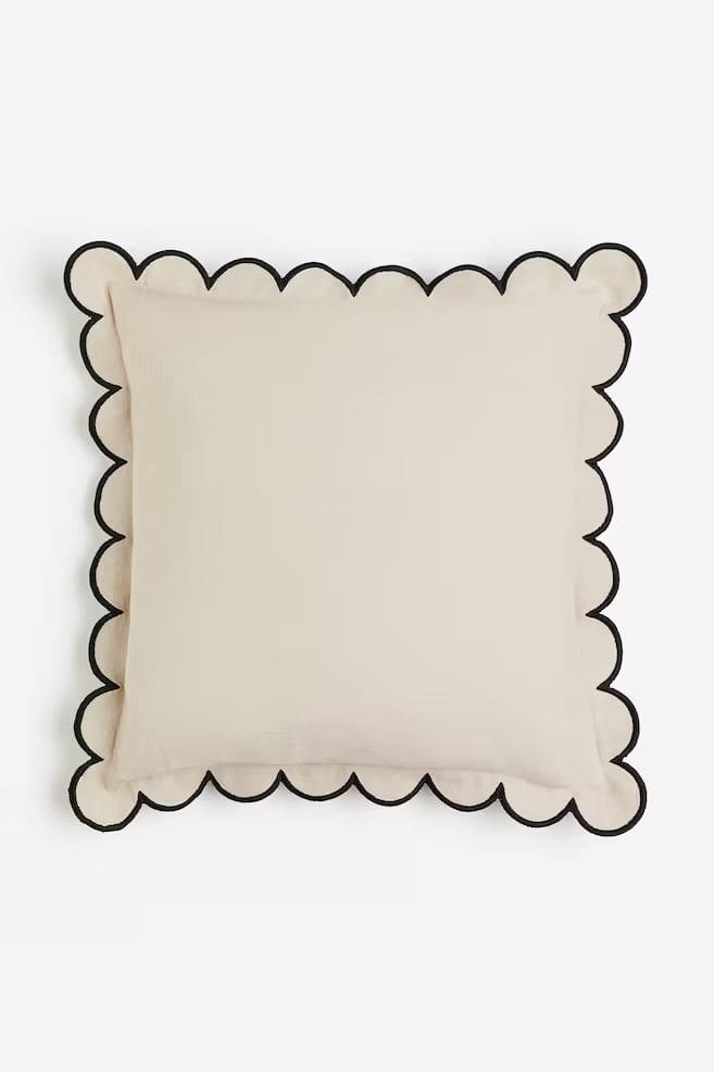 Off-white cushion with black trim scalloped edging