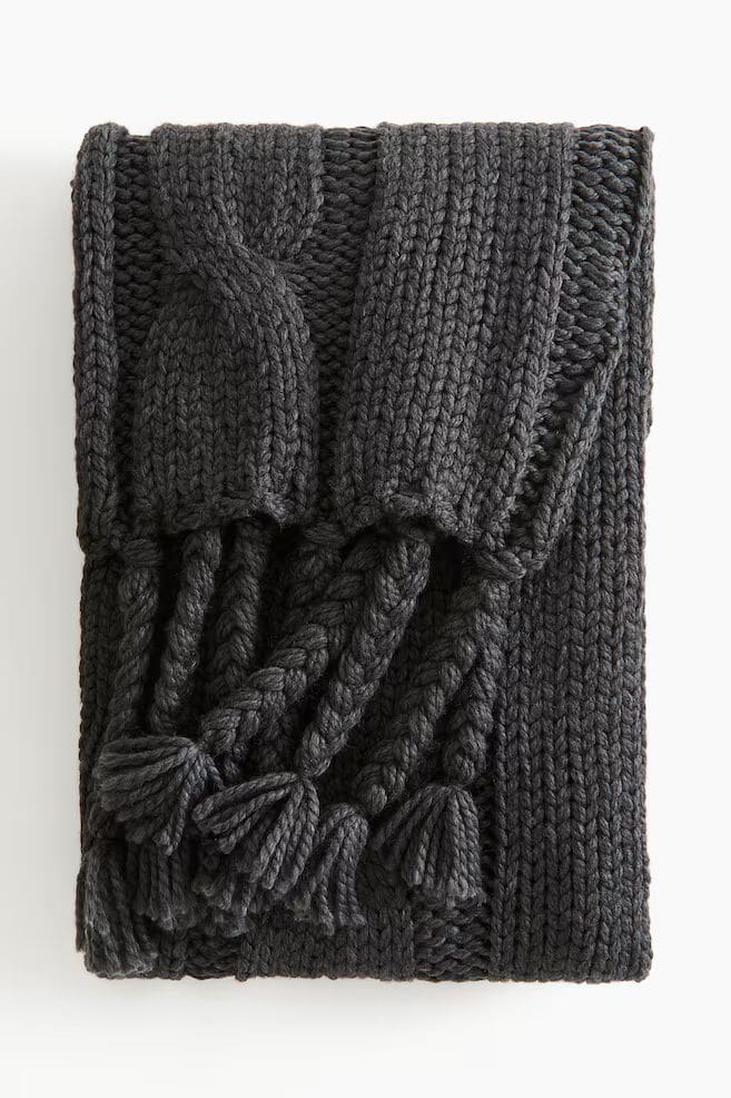 Dark grey knitted throw with plated tassel detail